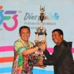 Direktur Poltekpar Makassar menyerahkan piala bergilir Porseni Poltekpar Makassar kepada Ketua Prodi Pengelolaan Konvensi dan Acara selaku Juara Umum Porseni Poltekpar Makassar Tahun 2024