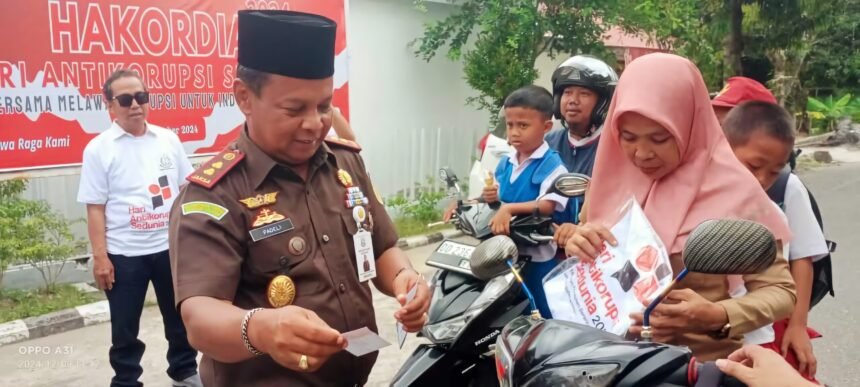 Padeli didampingi oleh Kepala Seksi Intelijen, Kepala Seksi Pidana Khusus, dan seluruh jajaran Kejari Enrekang, turun ke jalan membagikan stiker dan kaos bertema antikorupsi kepada masyarakat dan pengendara yang melintas, (9/12/2024). (Foto/IY/mediapesancom)