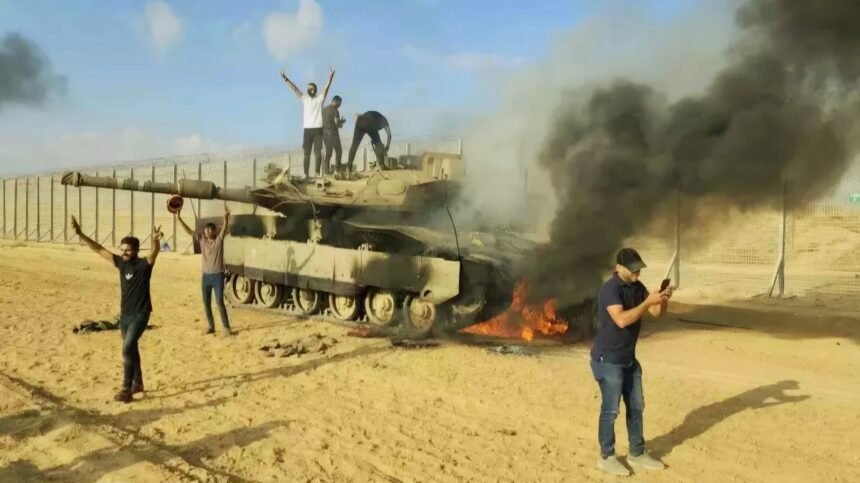 Warga Palestina merayakan tank Israel yang hancur di Jalur Gaza sebelah timur Khan Younis, Sabtu 7 Oktober 2023. (AP/HO)