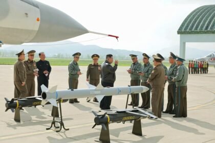 Pemimpin Tertinggi Kim Jong Un terlihat menginspeksi rudal di sebuah pangkalan udara, dikelilingi oleh perwira tinggi militer, Mei 2025. (kcna/ho/mp)