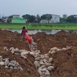 Keterangan Foto: Pekerja terlihat berada di atas tumpukan tanah dan batu yang menimbun saluran irigasi di kawasan proyek Namiland Tahap 3, Desa Kanjilo, Kecamatan Barombong, Kabupaten Gowa (23 Juni 2025). Penimbunan ini menuai kritik karena mengancam keberlangsungan pertanian warga yang bergantung pada aliran air dari saluran tersebut.