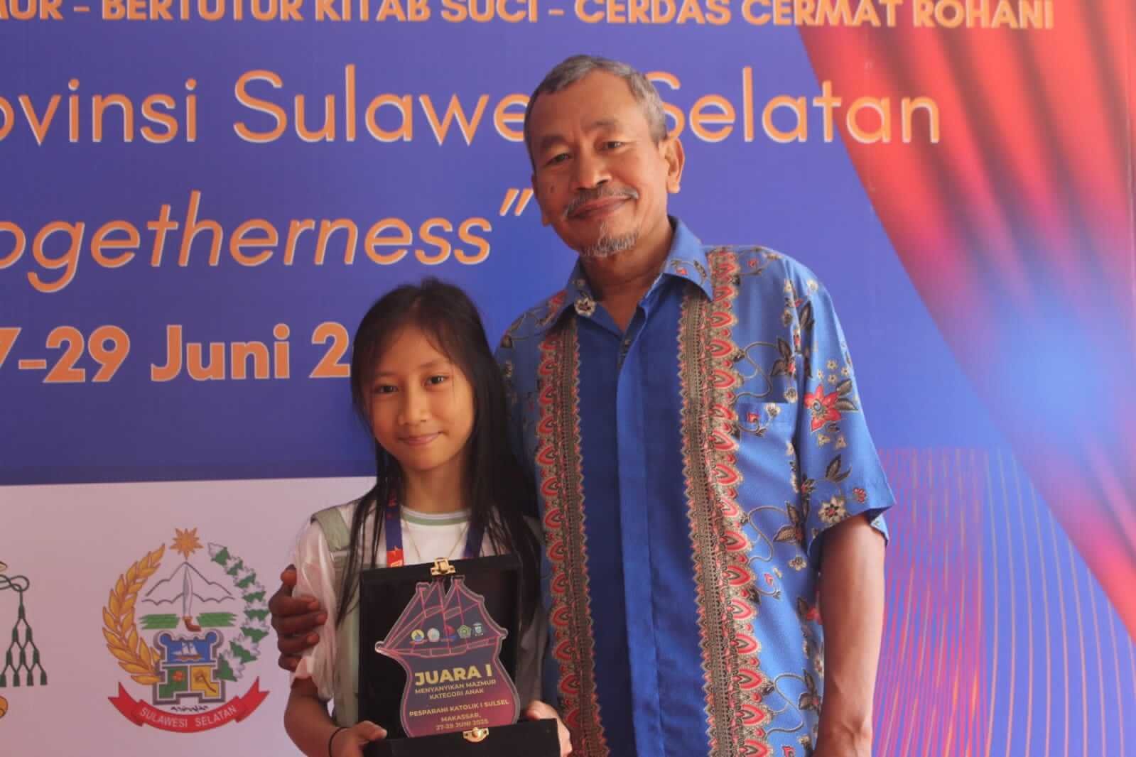 Stasi Mandai Maros Ukir Prestasi di Pesparani Sulsel I: Juara Mazmur Anak dari Kontingen Terkecil 3 Ketua LP3KD Maros, Benyamin Boy, bersama Frenelisya Gisela Payangan Kontingen Stasi Bunda Mandai Kabupaten Maros meraih predikat Juara I (Gold Champion),