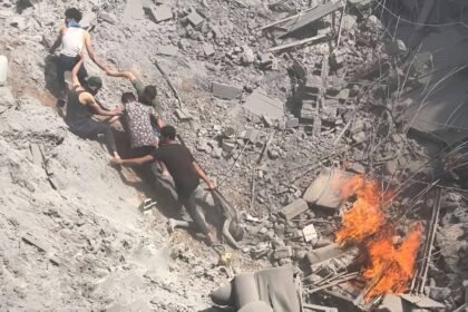 Lima pemuda Palestina bahu-membahu menarik tubuh tak bernyawa dari kawah reruntuhan bangunan oleh serangan udara Israel, Juni 2025. (qudsn/ho/mp)