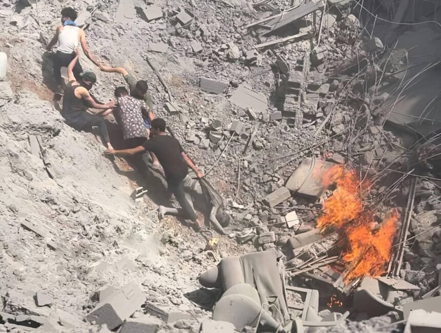 Lima pemuda Palestina bahu-membahu menarik tubuh tak bernyawa dari kawah reruntuhan bangunan oleh serangan udara Israel, Juni 2025. (qudsn/ho/mp)