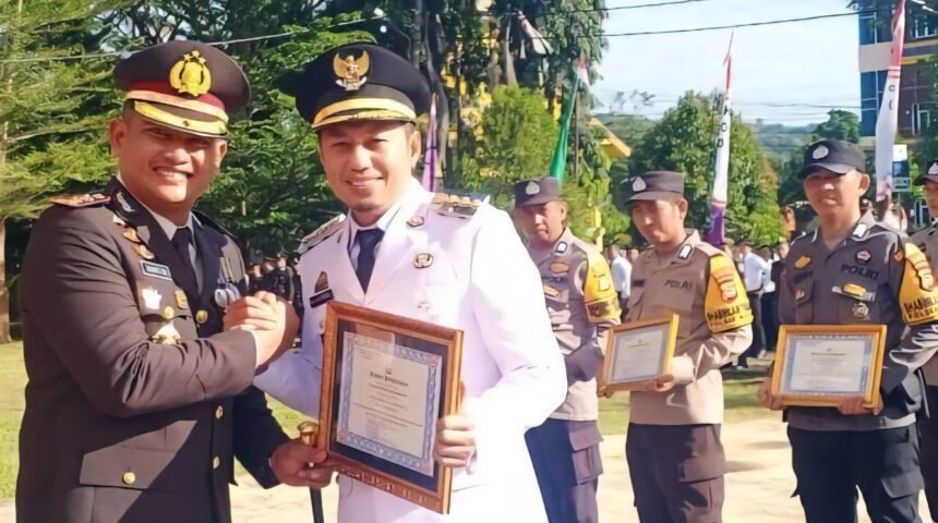 Kapolres Enrekang AKBP Hari Budiyanto memberikan penghargaan kepada Bupati Enrekang H. Muh. Yusuf Ritangnga dalam upacara peringatan Hari Bhayangkara ke-79 yang digelar di halaman Kantor Bupati Enrekang, Selasa (1/7/2025).