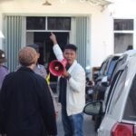 Seorang orator dari Aliansi Pemuda dan Masyarakat Tallo menyuarakan tuntutan di depan kantor CV. Kreatif Pisang Indonesia, BROWCYL, di Jalan Insinyur Juanda, Makassar (28/7/2025). Aksi ini menyoroti dugaan pelanggaran zonasi pergudangan di kawasan permukiman.
