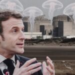 Presiden Prancis Emmanuel Macron di latar depan PLTN Gravelines, yang baru-baru ini padam total akibat serbuan ubur-ubur besar menyumbat sistem pendingin.