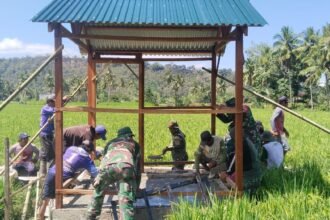 Keterangan foto: Babinsa Koramil 1419-02/Enrekang bersama warga Desa Buntu Batu bergotong royong mengecor dudukan mesin pompa air untuk mendukung program optimasi lahan pertanian, Selasa (2/9/2025).