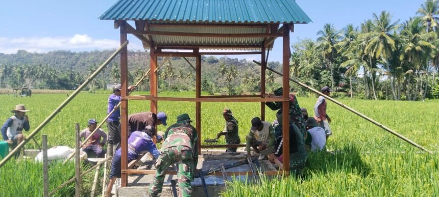 Keterangan foto: Babinsa Koramil 1419-02/Enrekang bersama warga Desa Buntu Batu bergotong royong mengecor dudukan mesin pompa air untuk mendukung program optimasi lahan pertanian, Selasa (2/9/2025).