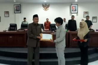 Plh Sekda Enrekang, Zulkarnain Kara, menyerahkan nota keuangan daerah dalam rapat paripurna DPRD Enrekang, Jumat (19/9/2025).