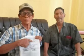 Warga Enrekang, Sukri, menunjukkan dokumen mediasi yang diduga dipalsukan tanda tangannya saat melaporkan kasus sengketa tanah.