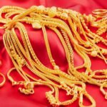 Deretan perhiasan emas dan logam mulia dipajang di atas kain merah. Lonjakan harga emas global ikut mengerek harga emas Antam di Indonesia hingga menembus rekor Rp2.086.000 per gram.