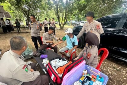 Petugas Sidokkes Polres Gowa memeriksa kesehatan warga saat kegiatan Bakti Kesehatan di sela Penanaman Jagung Serentak di Desa Romangloe, Gowa, Rabu (8/10/2025).