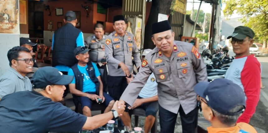 Kapolsek Tamalate Kompol Syarifuddin bersalaman dengan warga saat kegiatan silaturahmi dan sambang di Warkop Tuan Guru, Jongaya, Makassar, Jumat (10/10/2025). Kegiatan ini menjadi ruang dialog santai antara polisi dan masyarakat. (tim)