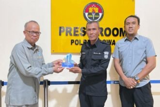 Dosen Pembimbing Lapangan Unismuh Makassar, Dr. Muhammad Yahya, M.Si, menyerahkan plakat apresiasi kepada perwakilan Humas Polres Gowa atas bimbingan selama program magang mahasiswi Ilmu Komunikasi, Selasa (14/10/2025).