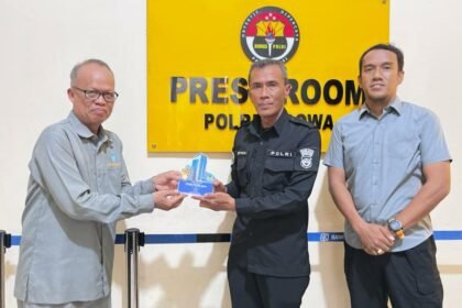 Dosen Pembimbing Lapangan Unismuh Makassar, Dr. Muhammad Yahya, M.Si, menyerahkan plakat apresiasi kepada perwakilan Humas Polres Gowa atas bimbingan selama program magang mahasiswi Ilmu Komunikasi, Selasa (14/10/2025).