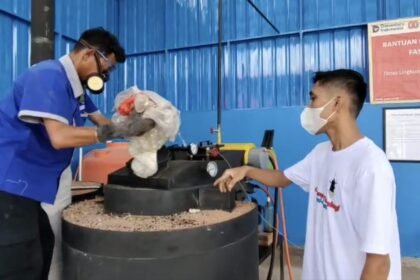 Petugas Pusat Daur Ulang Karimunjawa memasukkan sampah plastik ke mesin Fast Pyrolysis (Faspol), inovasi hasil kolaborasi PGN dan BRIN yang mengubah limbah plastik menjadi bahan bakar alternatif ramah lingkungan.