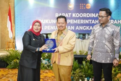 Dirjen Bina Pembangunan Daerah Kemendagri melalui Direktur SUPD IV menyerahkan cenderamata pada Rapat Koordinasi Dukungan Pemerintah Daerah untuk Penurunan Angka Kematian Ibu di Jakarta.