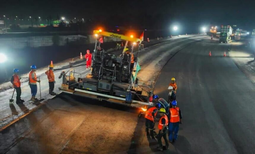 Pekerja jalan tol melakukan pengaspalan malam hari dengan alat berat untuk menjaga kualitas dan kelancaran proyek infrastruktur.