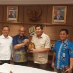 Menteri PKP dan perwakilan PWI Pusat berpose bersama usai penyerahan plakat sebagai simbol komitmen penyediaan 5.000 rumah subsidi bagi wartawan.