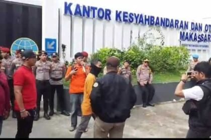 Jurnalis dan buruh berkumpul di depan KSOP Makassar setelah peliputan mediasi dibatasi oleh pihak otoritas pelabuhan.