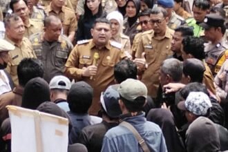 Wali Kota Makassar berdialog dengan massa aksi pedagang di halaman Balai Kota, Senin (12/1/2026), di tengah ketegangan terkait rencana penertiban pasar.
