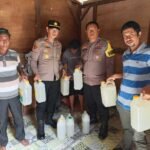 Petugas Polsek Namlea menunjukkan barang bukti 32 jerigen miras tradisional jenis sopi hasil razia KRYD di Kecamatan Namlea, Kabupaten Buru, jelang Ramadan 2026.