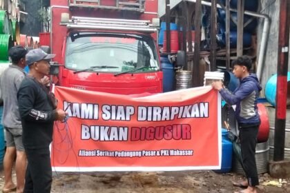 Pedagang drum di Jalan Bandang–Lamuru, Makassar, membentangkan spanduk bertuliskan “Kami siap dirapikan, bukan digusur” saat menyuarakan penolakan terhadap rencana penertiban.