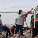 Personel Sat Intelkam Polres Pelabuhan Makassar membersihkan sampah plastik di kawasan Pelabuhan Paotere, Rabu (4/2/2026).