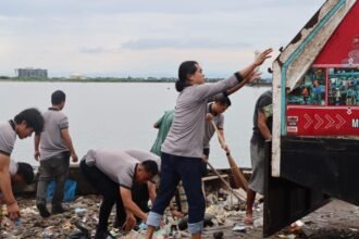 Personel Sat Intelkam Polres Pelabuhan Makassar membersihkan sampah plastik di kawasan Pelabuhan Paotere, Rabu (4/2/2026).