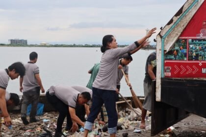 Personel Sat Intelkam Polres Pelabuhan Makassar membersihkan sampah plastik di kawasan Pelabuhan Paotere, Rabu (4/2/2026).