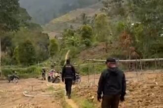 Petugas menyusuri lokasi yang diduga menjadi tempat judi sabung ayam di Dusun Bulo, Enrekang.