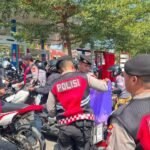 Personel Polresta Gowa turun langsung mengatur lalu lintas dan juga membagikan air minum dan roti kepada warga yang menunggu giliran mengisi BBM, Minggu (13/9/2026).