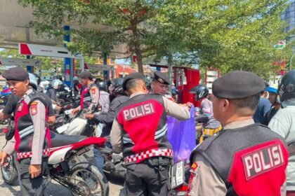 Personel Polresta Gowa turun langsung mengatur lalu lintas dan juga membagikan air minum dan roti kepada warga yang menunggu giliran mengisi BBM, Minggu (13/9/2026).
