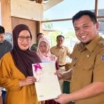 Wakil Bupati Enrekang Andi Tenri Liwang Latinro menyerahkan sertifikat tanah kepada masyarakat Desa Tampo melalui program PTSL 2026. (ft/ho)