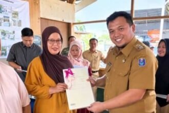 Wakil Bupati Enrekang Andi Tenri Liwang Latinro menyerahkan sertifikat tanah kepada masyarakat Desa Tampo melalui program PTSL 2026. (ft/ho)