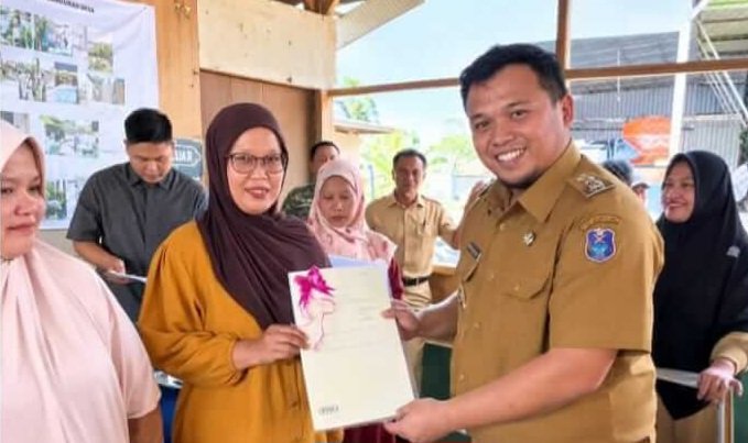 Wakil Bupati Enrekang Andi Tenri Liwang Latinro menyerahkan sertifikat tanah kepada masyarakat Desa Tampo melalui program PTSL 2026. (ft/ho)